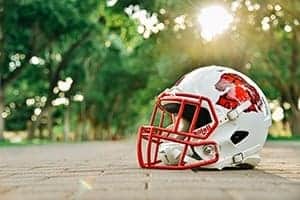 High school football helmet on field at Albuquerque Academy campus in sunny outdoor setting.