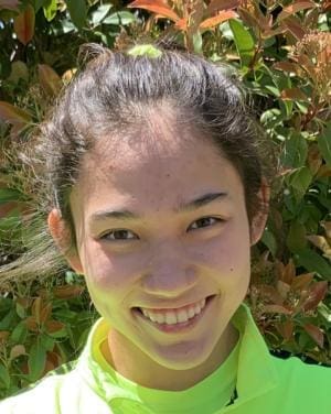 Albuquerque Academy student smiling outdoors in vibrant greenery.