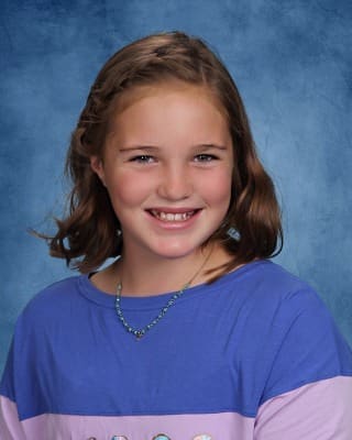Bright smiling girl at Albuquerque Academy campus, showing vibrant student life.