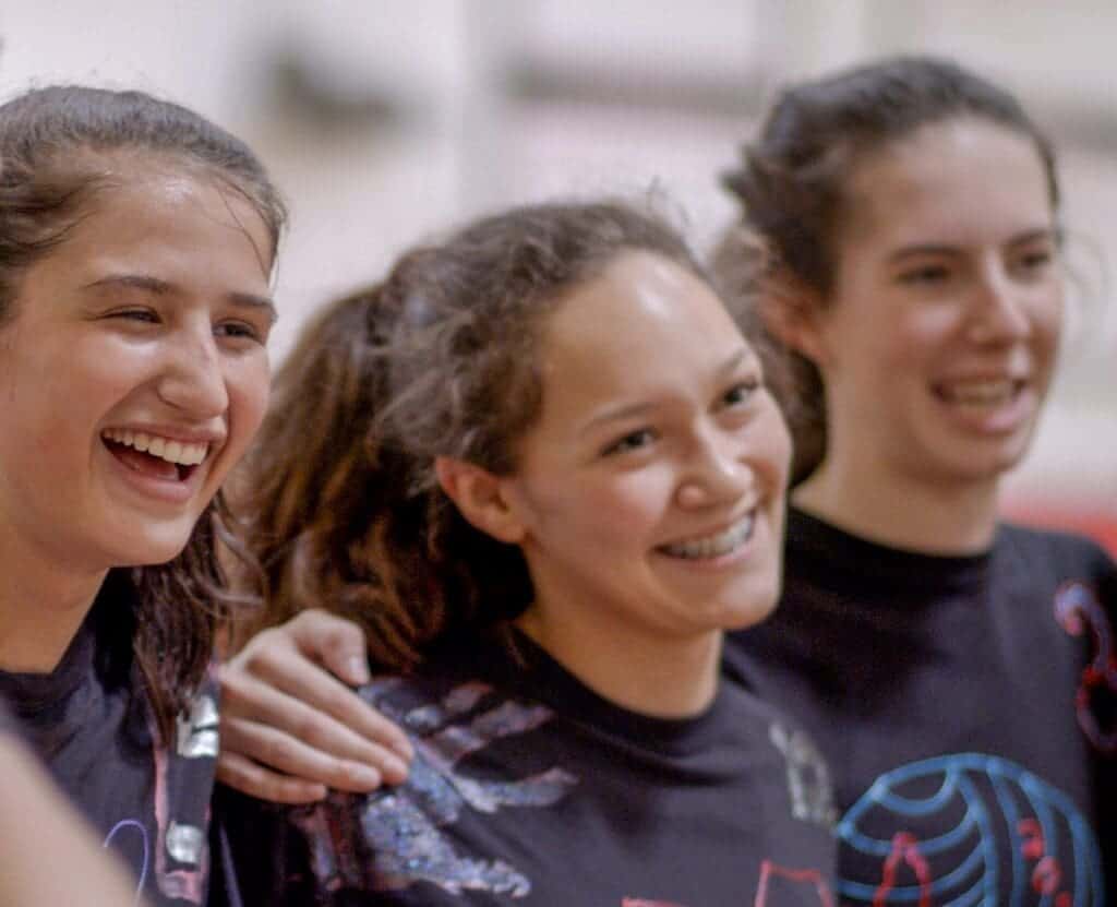 Smiling students at Albuquerque Academy sports event promoting academic excellence and school spirit.