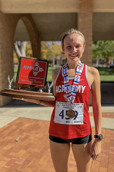 Albuquerque Academy student wins cross country championship with trophy and medal.