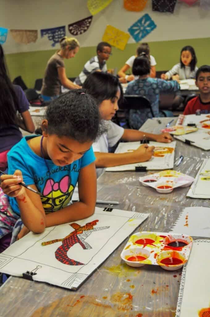 Colorful art class with diverse students painting at Albuquerque Academy campus.