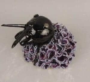 A ceramic beetle in a flower skirt