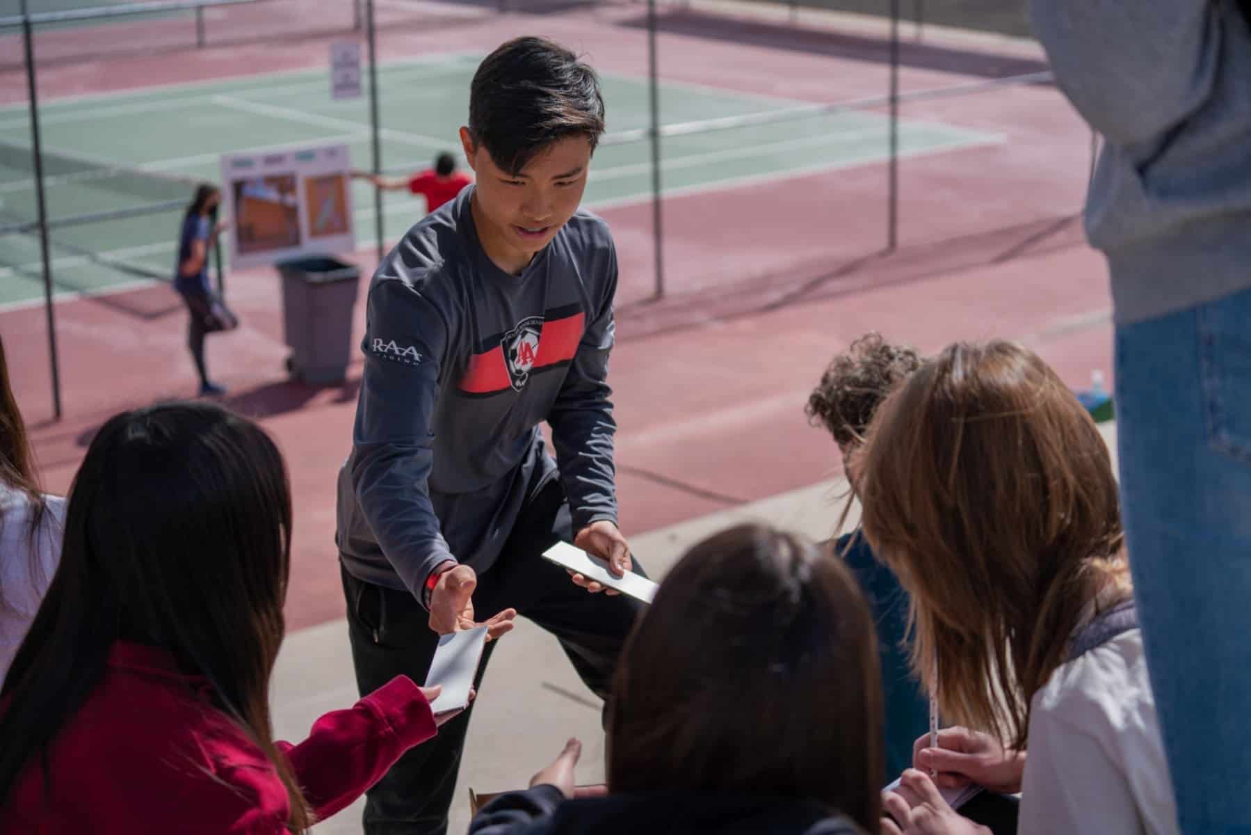 Young students at Albuquerque Academy discussing outdoors on school campus.
