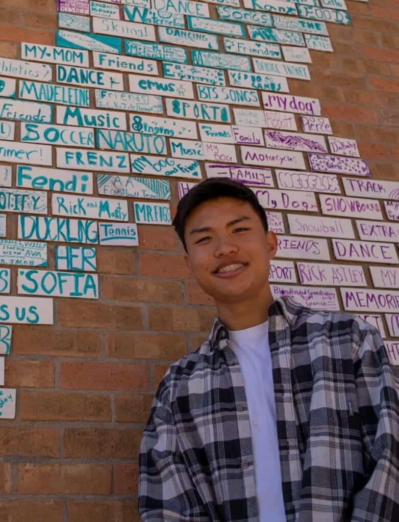 Engaging student at Albuquerque Academy with colorful wall art of student activities and interests.