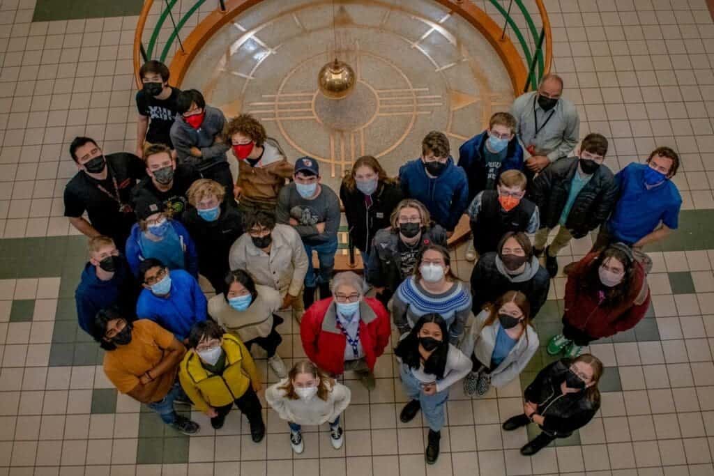 Diverse group of students and teachers at Albuquerque Academy, exploring campus history.