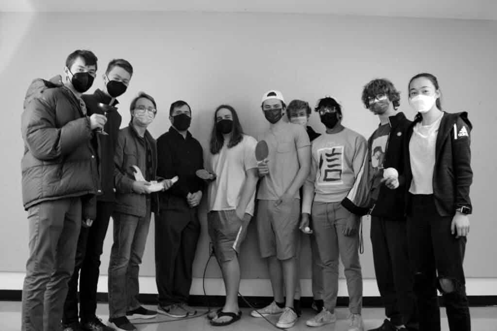Group of diverse students wearing masks at Albuquerque Academy standing against plain wall.