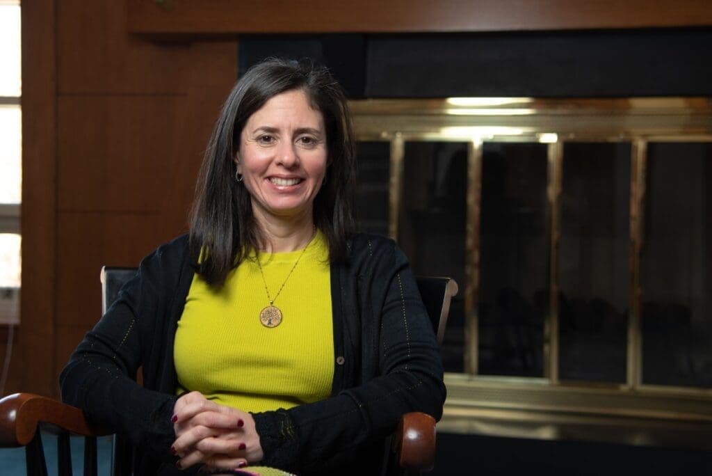 Engaged woman in a vibrant yellow top at Albuquerque Academy, educational excellence and community focus.
