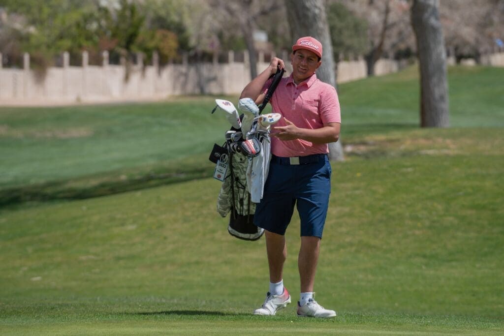 Young man carrying golf bag on a golf course, outdoor sports at Albuquerque Academy.