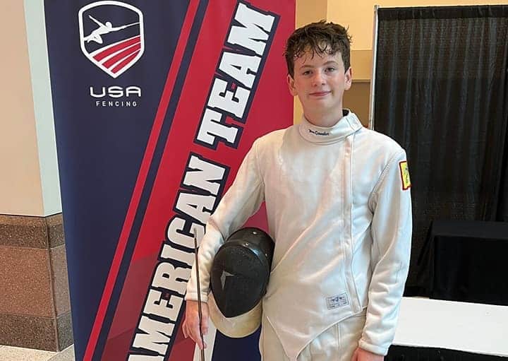 Young fencer in uniform at Albuquerque Academy US fencing event.