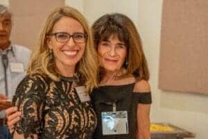Diverse women smiling at Albuquerque Academy event, professional and community gathering.