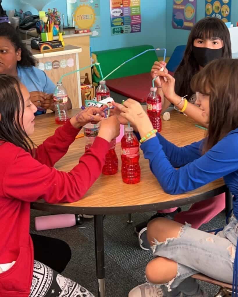 Colorful classroom with children conducting science experiment at Albuquerque Academy.