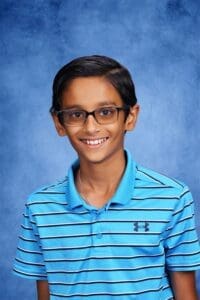 Bright student at Albuquerque Academy in a blue striped polo shirt with glasses.