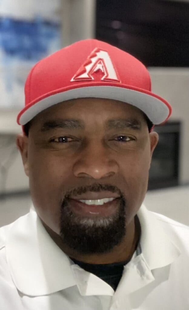 Friendly man wearing baseball cap with Arizona Diamondbacks logo, smiling.