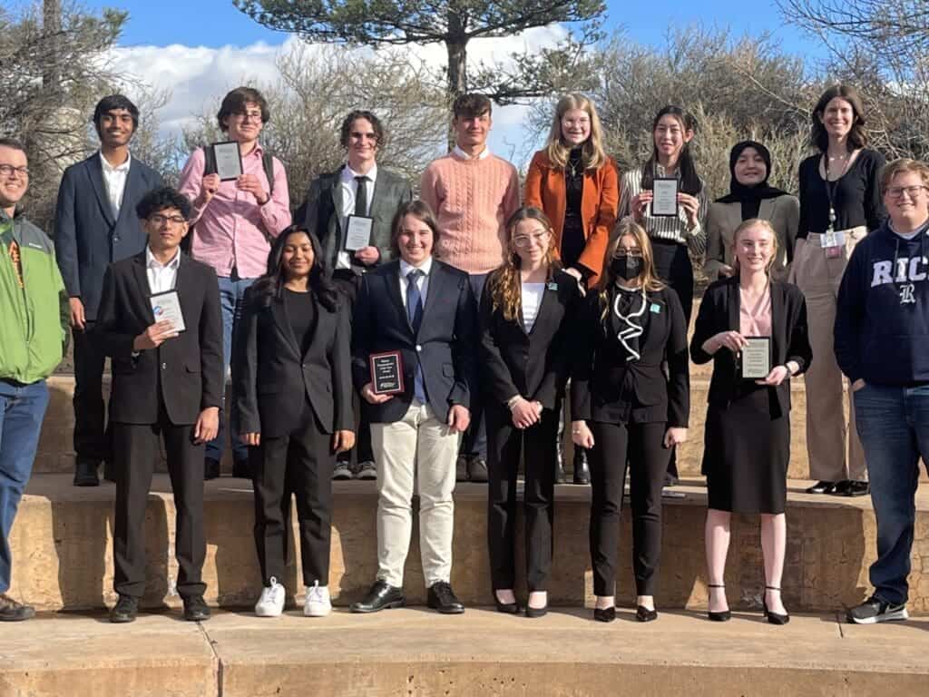 Diverse students at Albuquerque Academy celebrating academic achievements outdoors.