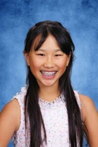 Bright smiling student at Albuquerque Academy with braces and long dark hair.