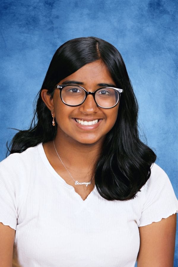 Smiling female student with glasses at Albuquerque Academy for academic excellence.