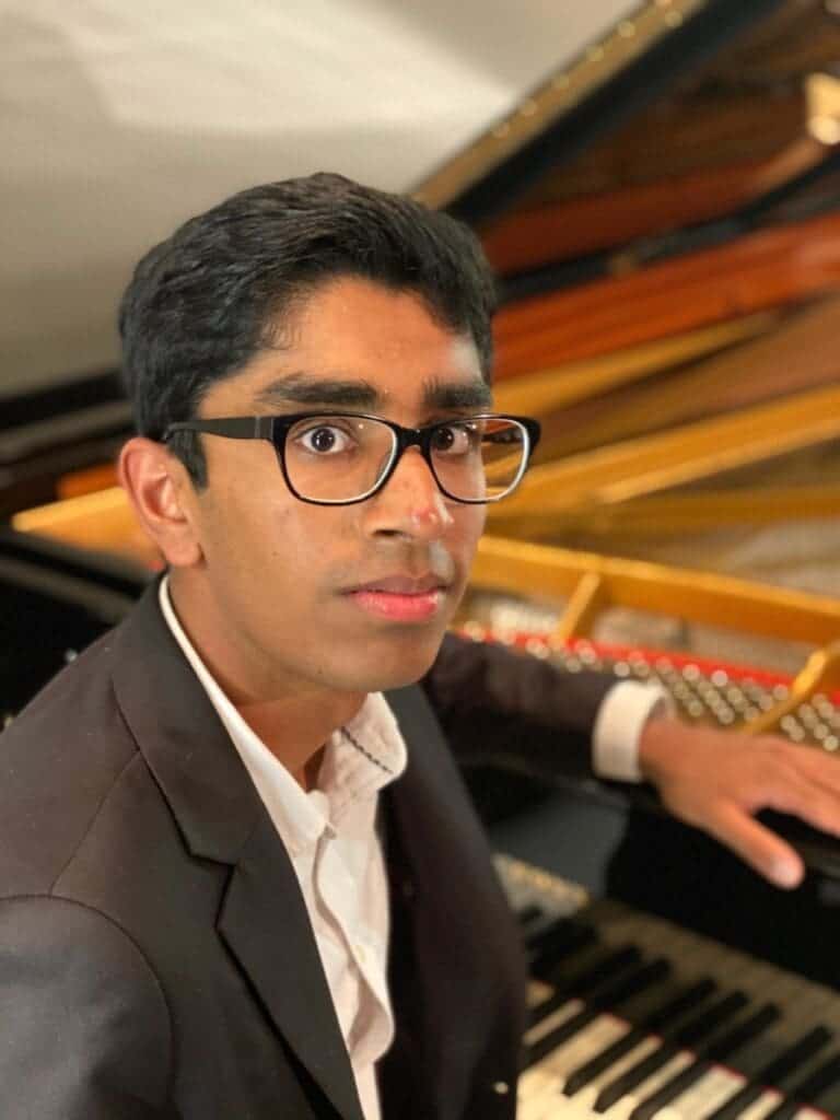 Skilled student playing grand piano at Albuquerque Academy music program.
