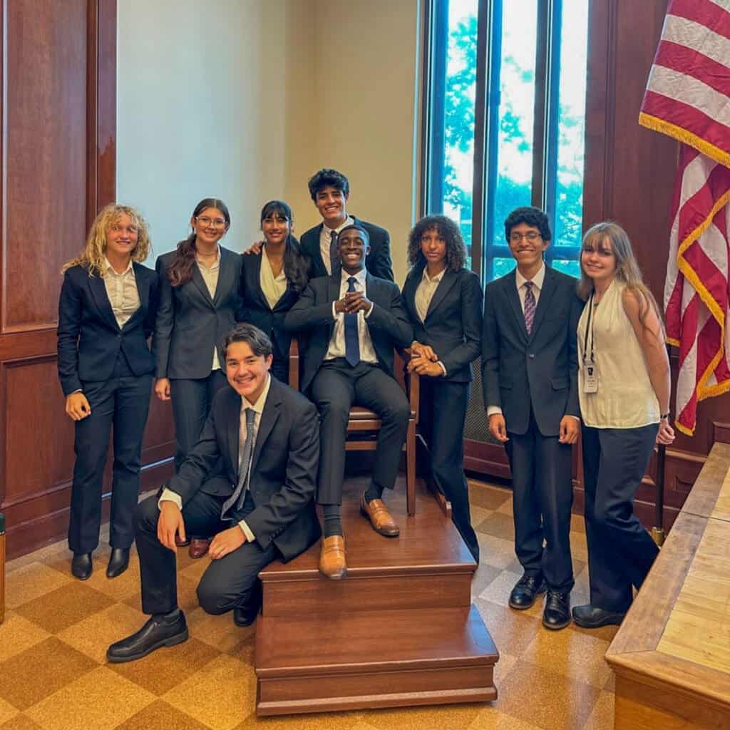 Diverse students in formal attire at Albuquerque Academy courtroom mock trial.