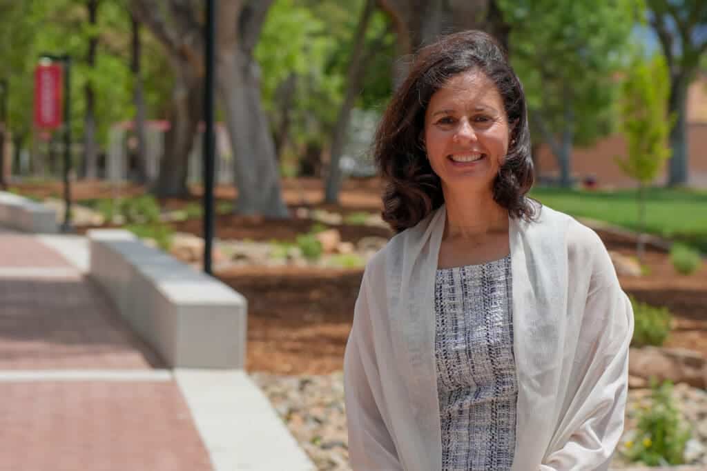 Elegant woman outdoors on Albuquerque Academy campus in spring.