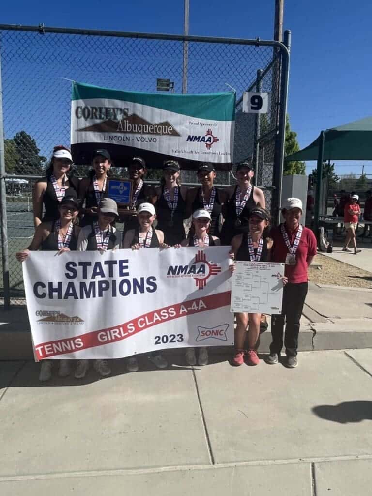 Girls tennis team celebrating state championship victory at Albuquerque Academy.