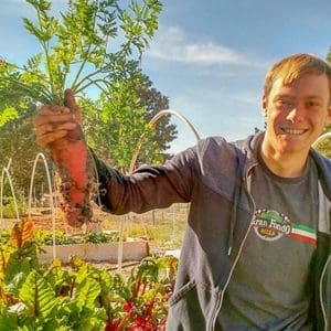 Healthy student harvesting fresh carrots from Albuquerque Academy garden.
