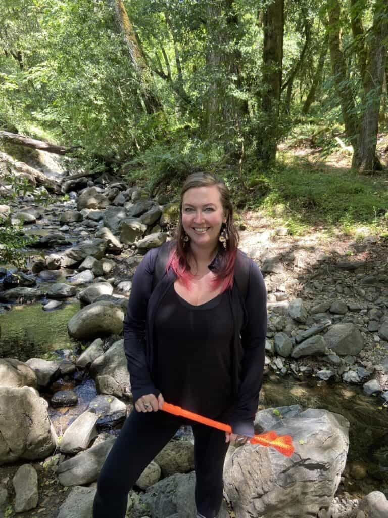 Lush forest and creek at Albuquerque Academy campus with smiling woman explorer.