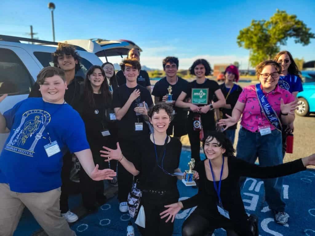 Students celebrating victory at Albuquerque Academy science competition outdoor event, energetic and proud, diverse youth, bright sunny day.