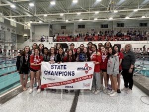 Girls' swim team celebrating state championship victory.