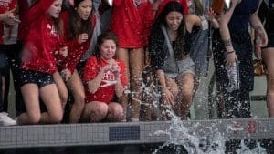 Swim team members cheering by the poolside.