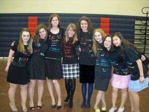 An energetic group of Albuquerque Academy students dressed in personalized shirts celebrate school spirit.