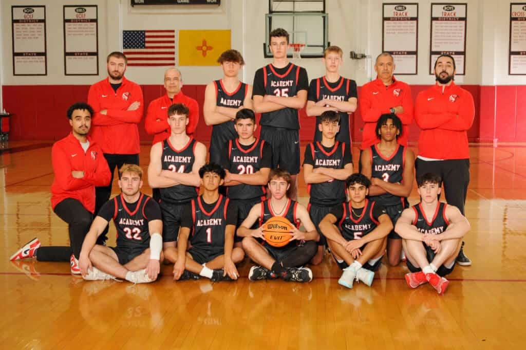 High school basketball team group photo in gym.