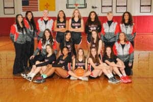 High school girls basketball team photo in gymnasium.
