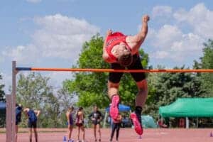 Athlete performing high jump at outdoor track meet.
