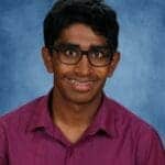 Smiling teen with glasses and braces, purple shirt.