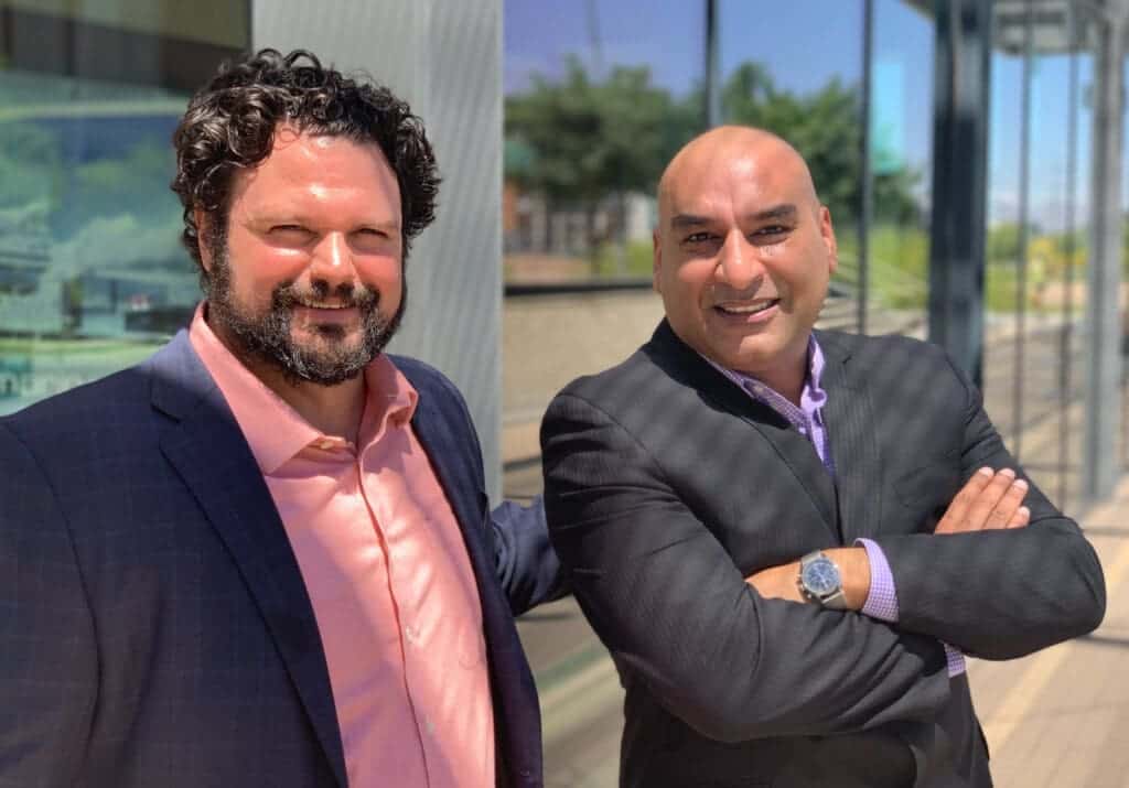 Diverse professional men smiling outside Albuquerque Academy in New Mexico, demonstrating leadership and school excellence.