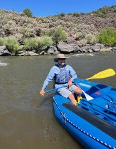 Albuquerque academy student kayaking on river in outdoor education program.
