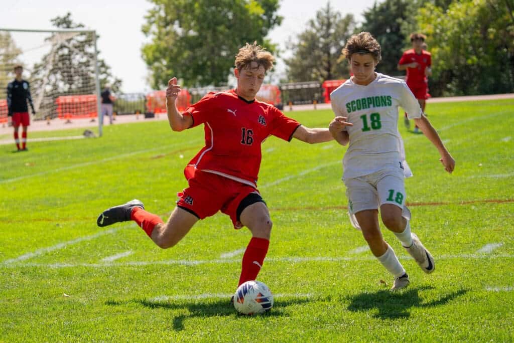 Albuquerque Academy student athletes playing soccer on a lush green field.