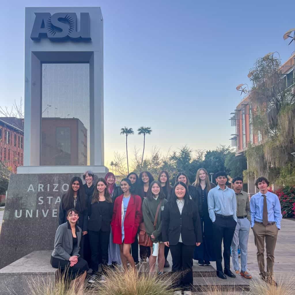 Albuquerque academy students group outside campus with ASU sign in background.