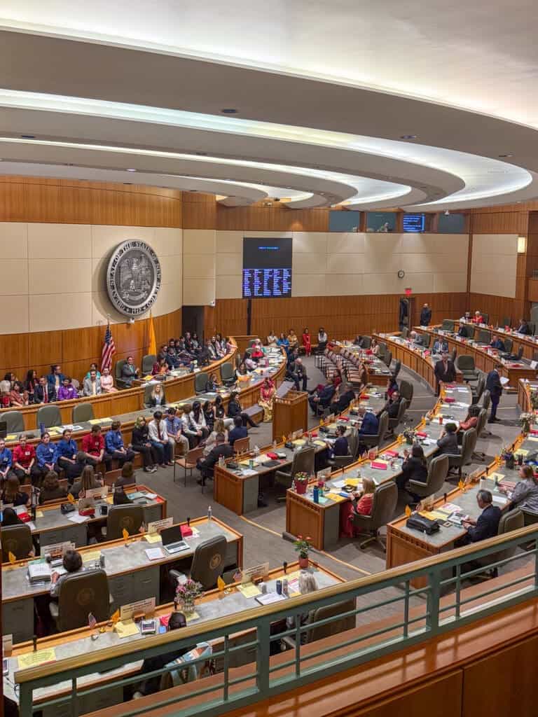 Albuquerque Academy, diverse students and staff in a government or council chamber for educational events.