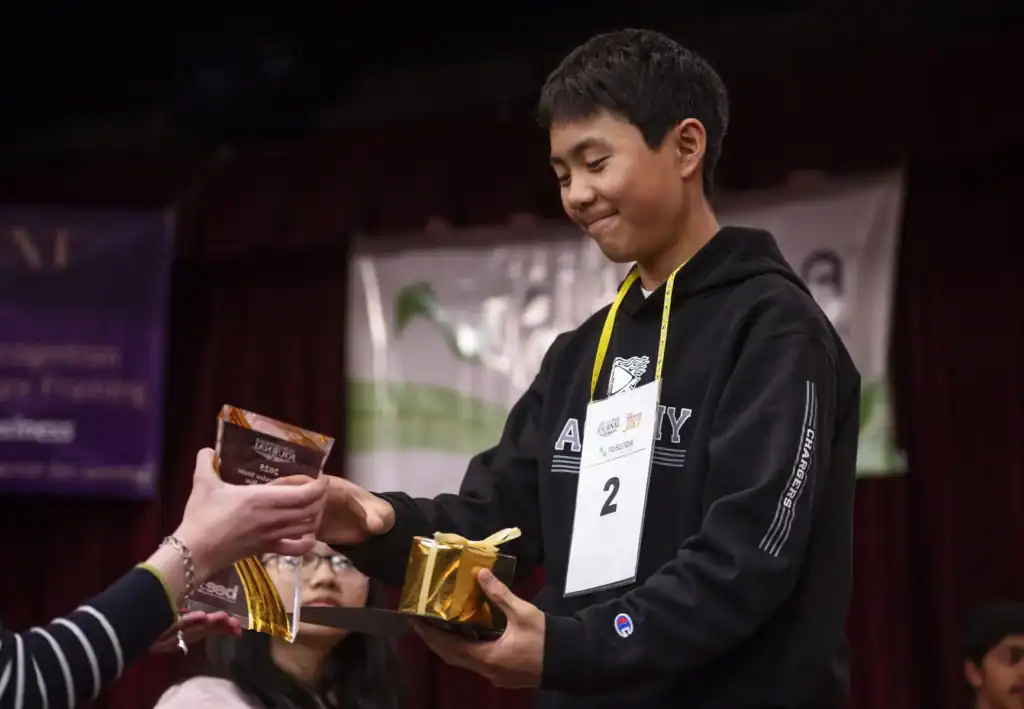 Albuquerque Academy student receiving award at school event.