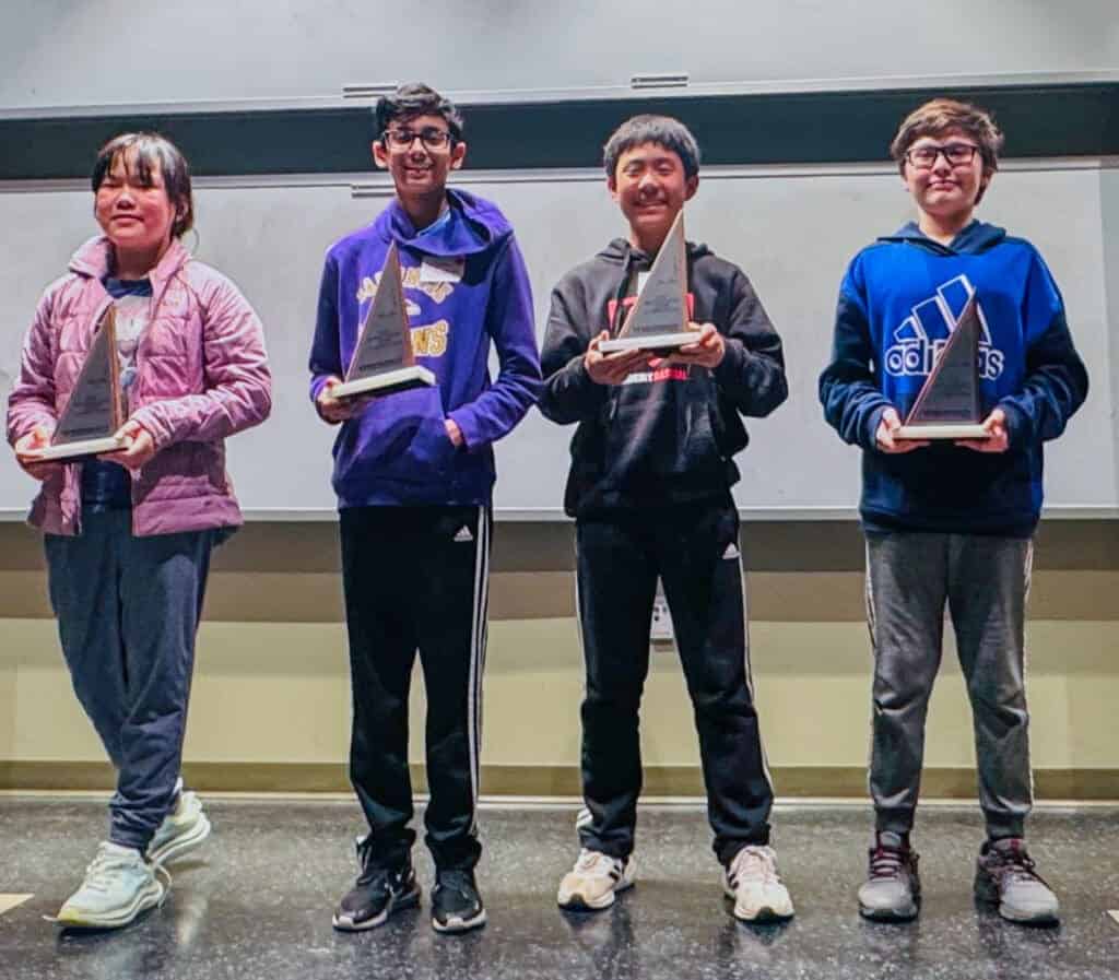 Albuquerque Academy students holding awards at a school event.