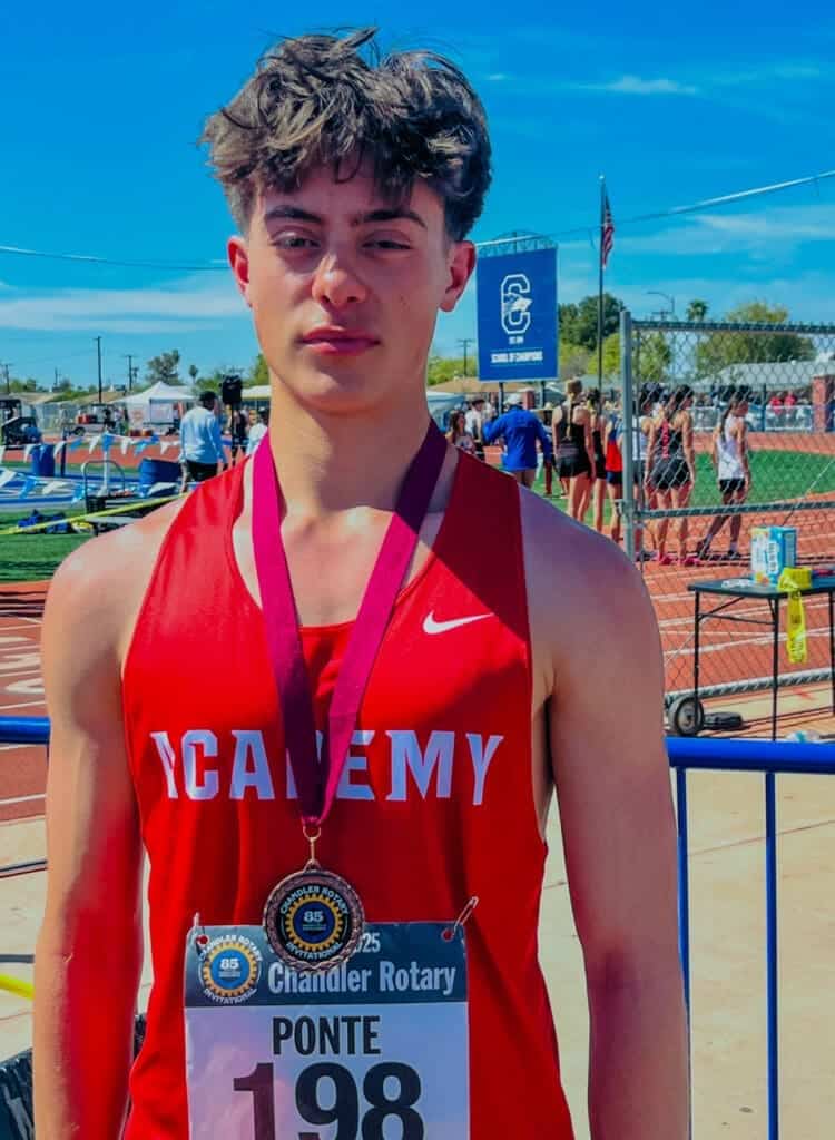 Student athlete wearing Albuquerque Academy uniform at track and field event, representing the school's athletic program.