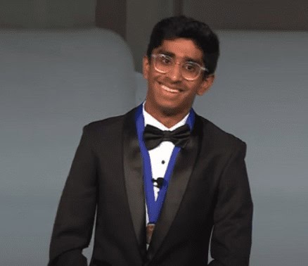 Young student in tuxedo smiling at Albuquerque Academy graduation event.