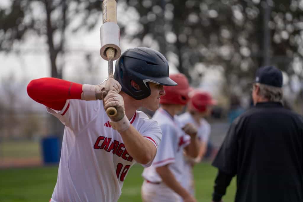 Albuquerque Academy baseball player preparing to bat during a game.