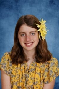 Albuquerque Academy student portrait with yellow flower hair accessory.