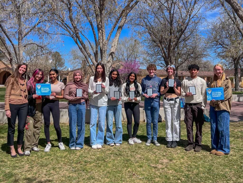 Young students celebrating academic achievement outdoors at Albuquerque Academy campus.