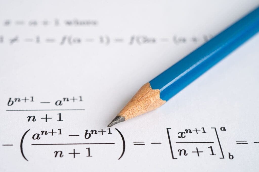 Pencil on math worksheet with algebra and calculus equations, studying advanced mathematics at Albuquerque Academy.