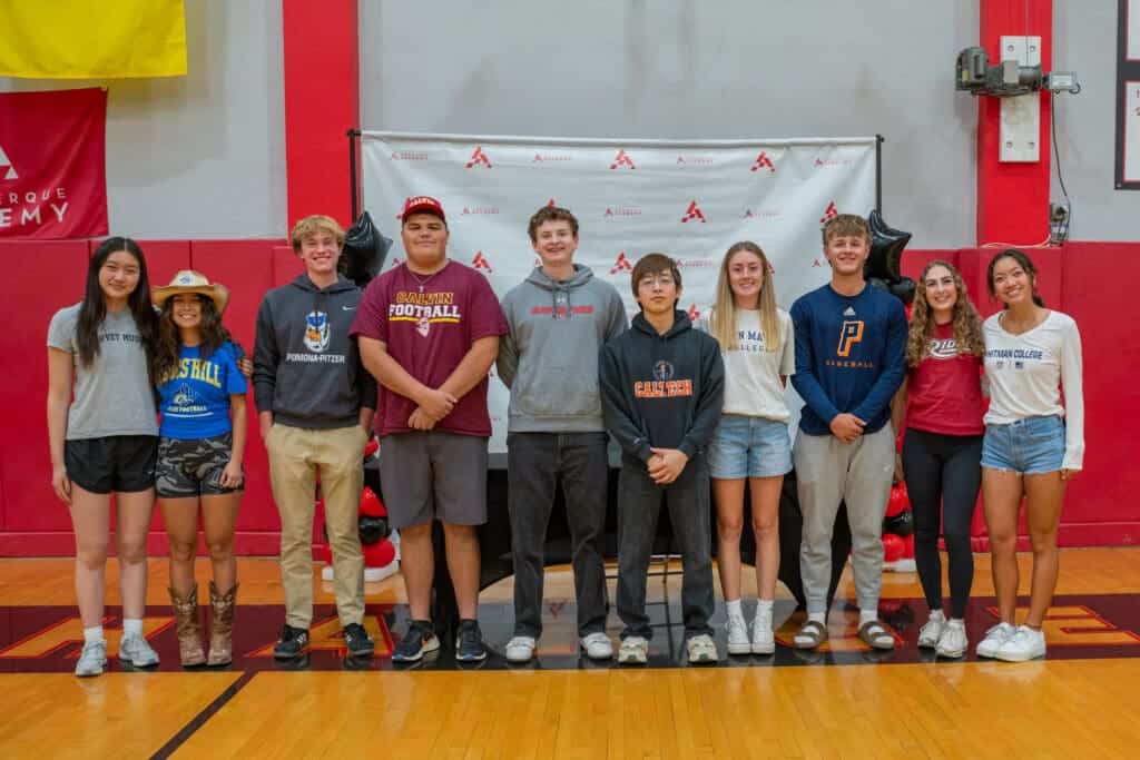 Students at Albuquerque Academy school event posing for a group photo inside the gymnasium.