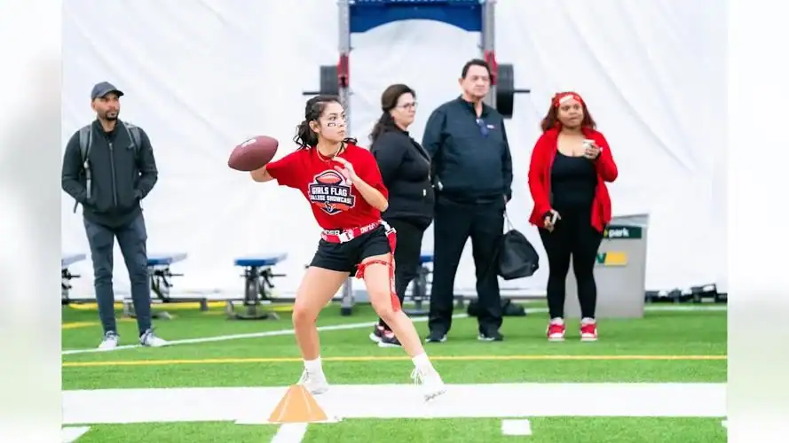 Albuquerque academy students participating in football drill indoor sports facility.